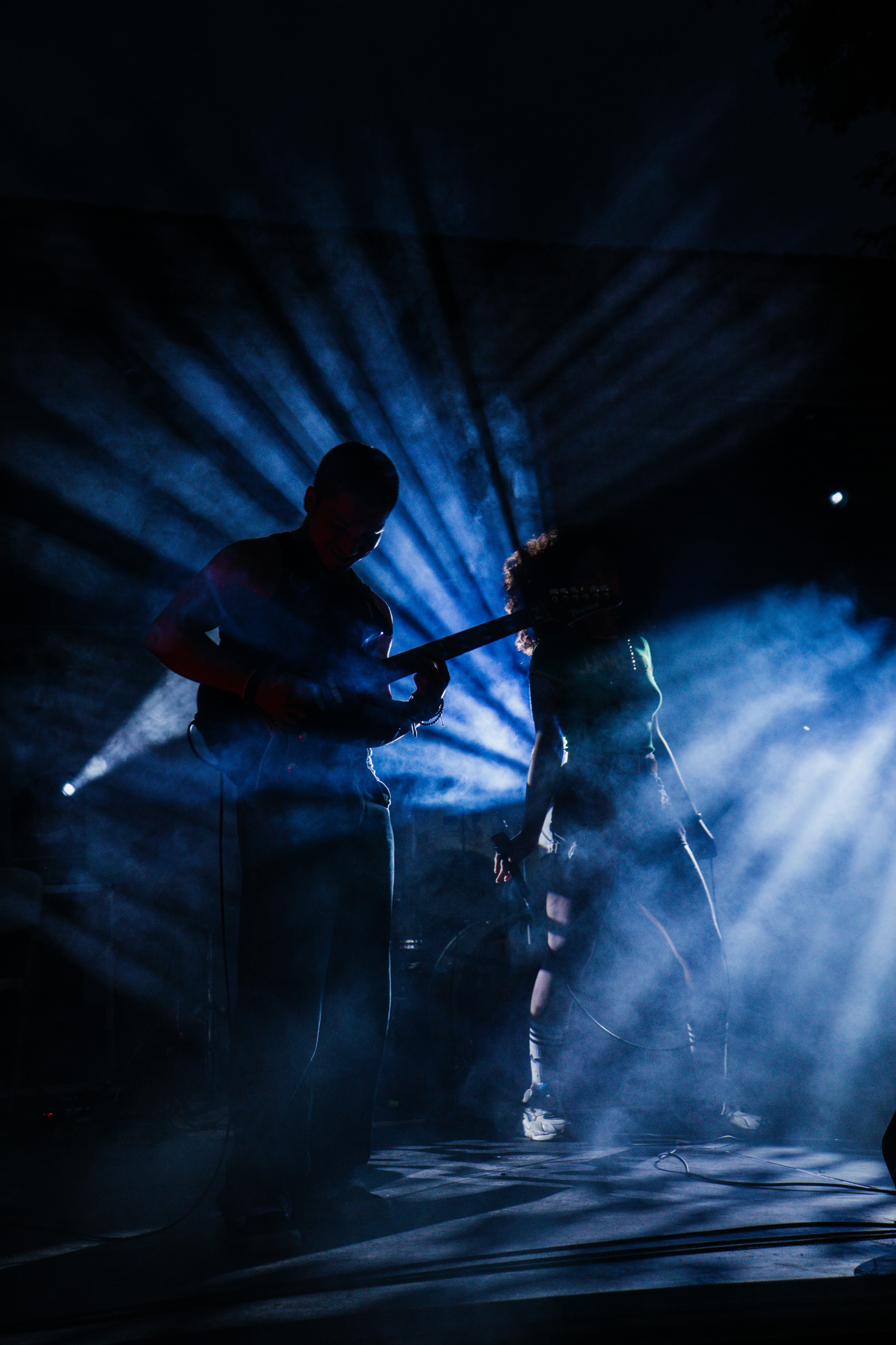 Performer silhouetted against stage lighting